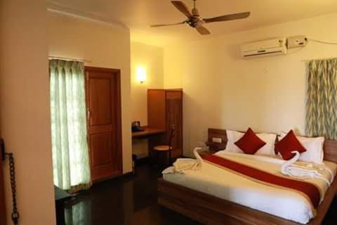 sypialnia z łóżkiem i wentylatorem sufitowym w obiekcie ZIONS APARTMENT w mieście Devanhalli