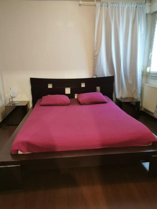a bed with a pink blanket on top of it at appartement cosy à 10 min du centre de Strasbourg in Strasbourg