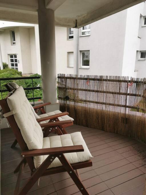 a rocking chair and an umbrella on a porch at appartement cosy à 10 min du centre de Strasbourg in Strasbourg