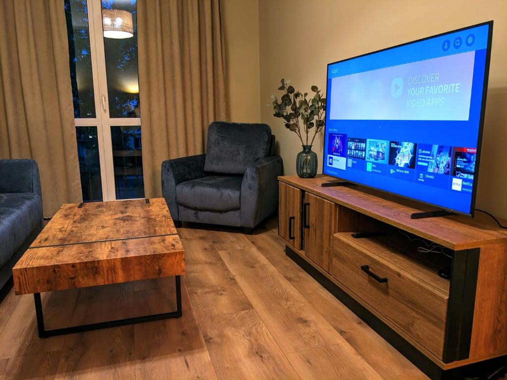 uma sala de estar com uma grande televisão de ecrã plano em Two bedrooms, close to the center, fully equipped! em Cracóvia
