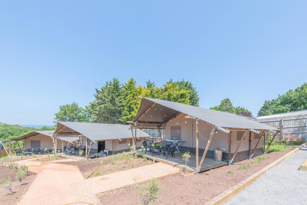 a group of tents in a yard with trees at Luxury Glamping at Stags Head in Abbotskerswell