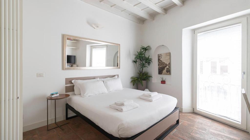 a bedroom with a bed with a mirror and a window at Italianway - Argelati 2 in Milan