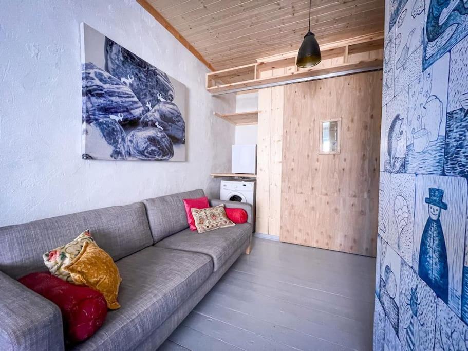 ein Wohnzimmer mit einem grauen Sofa in einem Zimmer in der Unterkunft Fairytale apartment in Viljandi old town in Viljandi