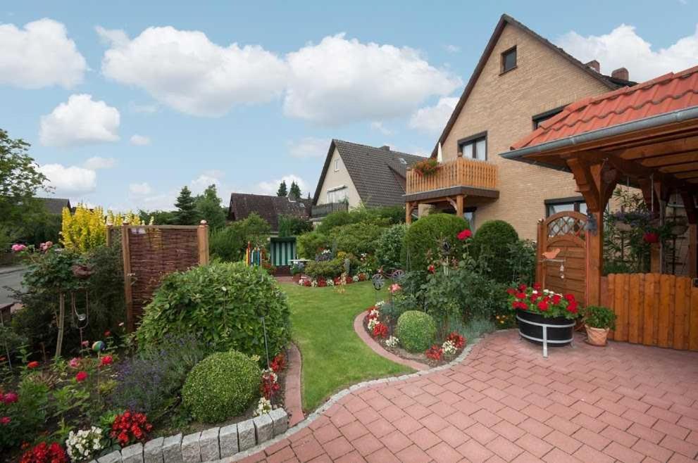 uma casa com um jardim com flores e uma entrada de tijolos em Ferienwohnung Regner em Bad Bevensen