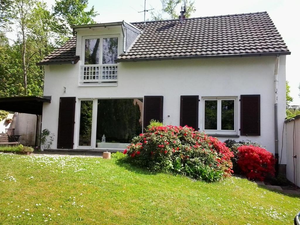 ein weißes Haus mit schwarzen Fenstern und einem grünen Hof in der Unterkunft Villa Donar in Köln