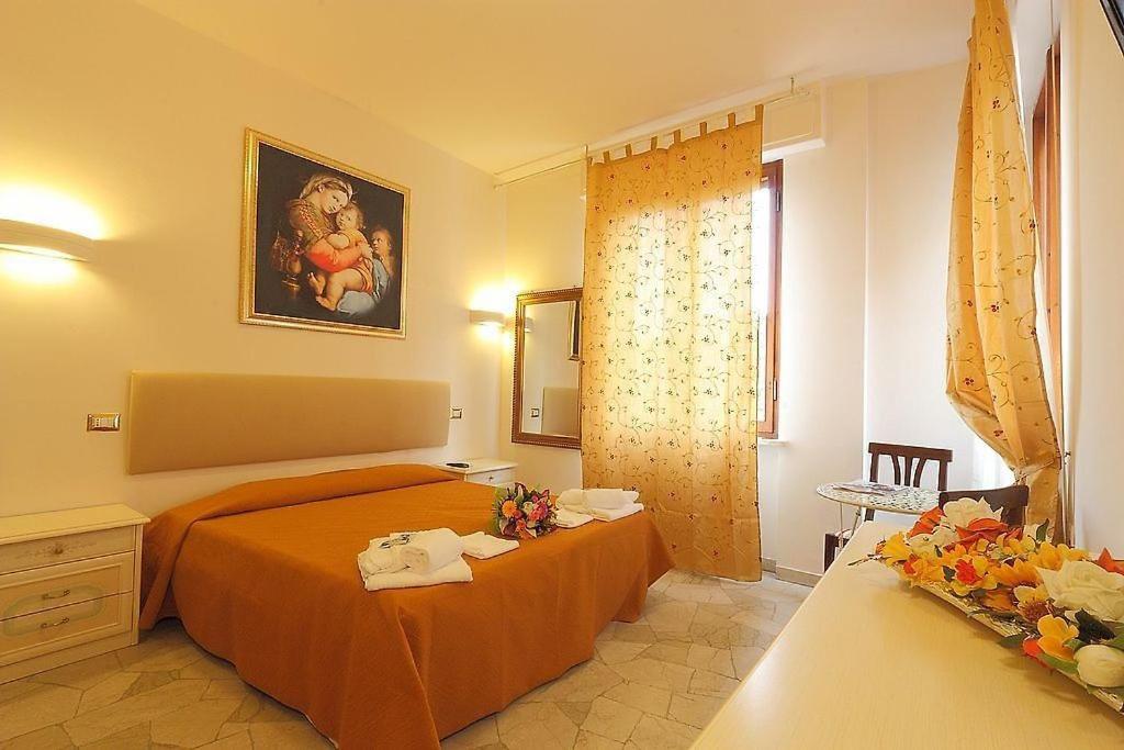 a bedroom with a bed with orange sheets and a window at Arcadia GuestHouse in Florence