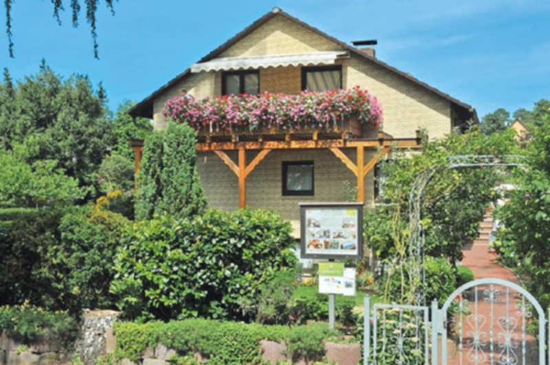 a house with a balcony with flowers on it at Ferienwohnungen Haus Bahlo in Bad Bevensen