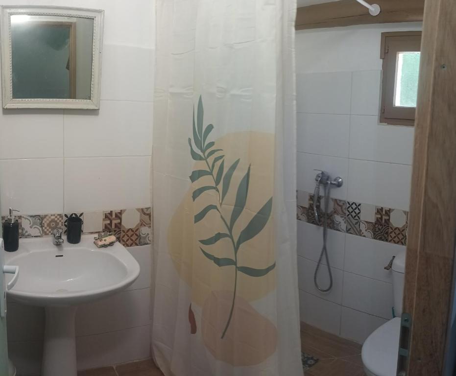 baño con lavabo y cortina de ducha en 7-gîte-7 personnes au cœur de la nature /piscine, en Saint-Aubin-de-Nabirat