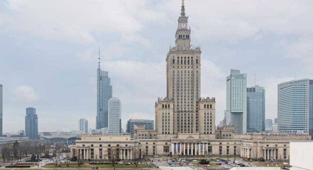 a large building with a clock tower in a city at Apartments Golden Warsaw by Noclegi Renters in Warsaw