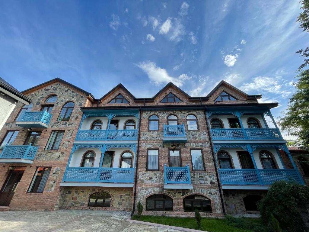 un gran edificio de ladrillo con balcones azules en Chateau Orberi en Ikalto