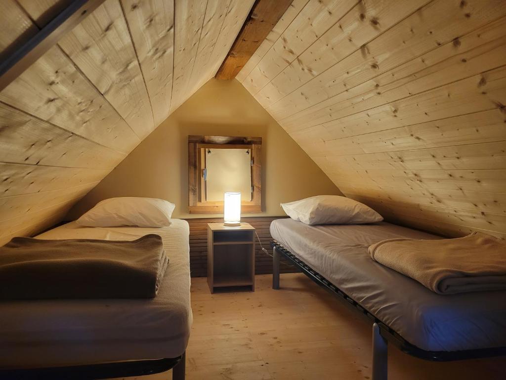 a attic room with two beds and a lamp at Camping Borepo in Villeveyrac