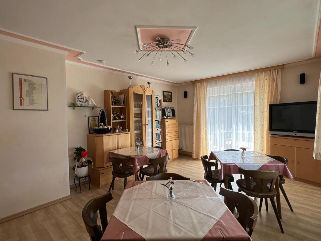 un soggiorno con due tavoli, sedie e TV di Feistritzer a Seeboden