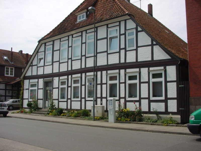 een zwart-wit gebouw aan de straatkant bij Ferienwohnungen Ehlers-Bastelstudio in Bad Bevensen