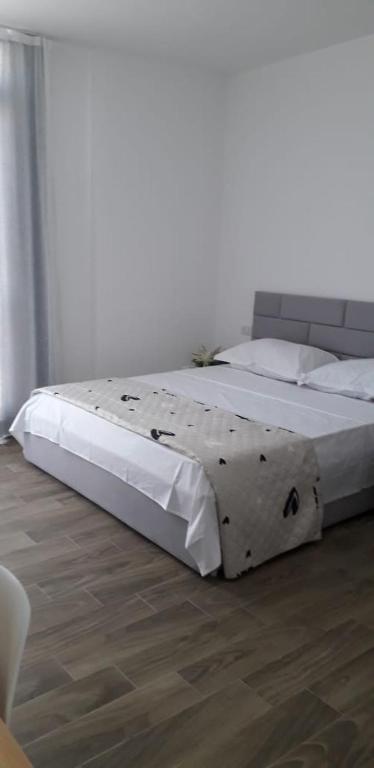 a large bed in a bedroom with a wooden floor at Joy Summer Apartment in Skataj