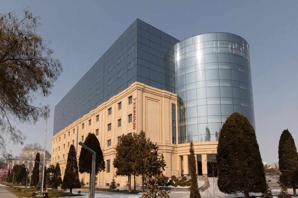a large building with a glass and metal at Mövenpick Samarkand in Samarkand