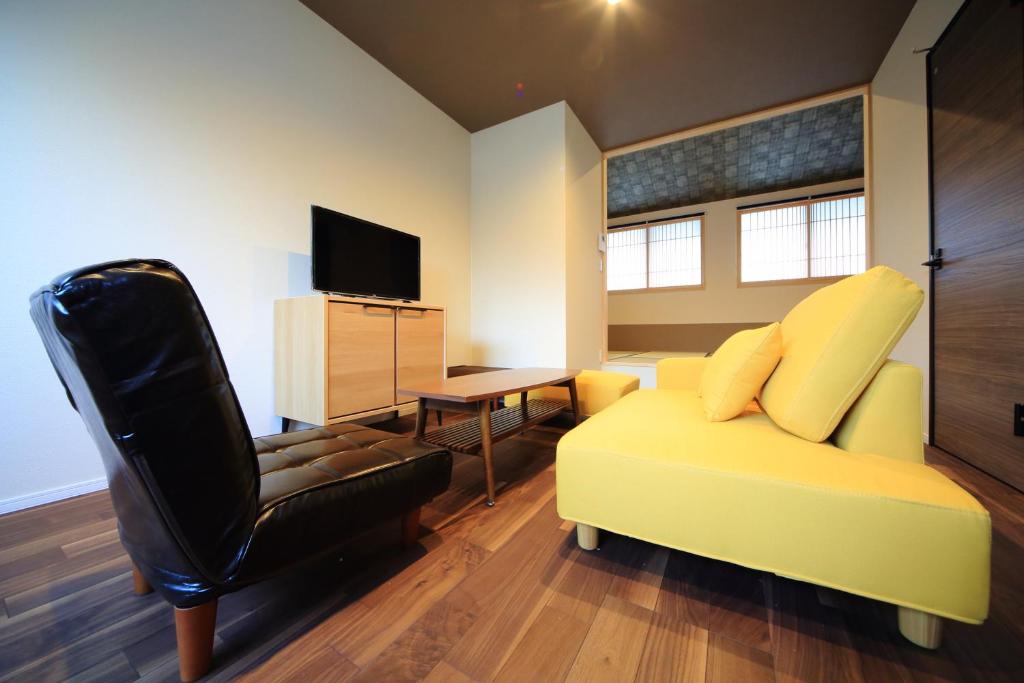 uma sala de estar com um sofá amarelo e uma cadeira em 柏・清水2（Haku Kiyomizu2） em Quioto