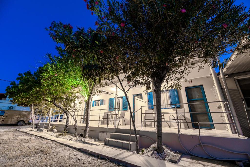 un edificio con finestre blu e alberi di fronte ad esso di Zante Riva Studios a Lithakia