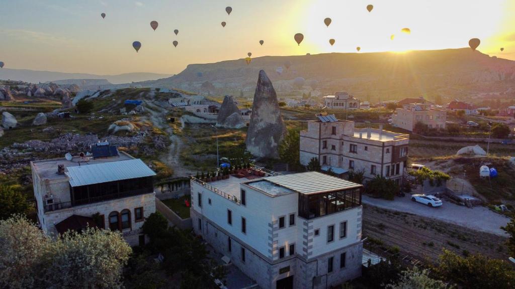 un grupo de globos de aire caliente volando sobre una ciudad en IVY Cappadocia, en Nevşehir