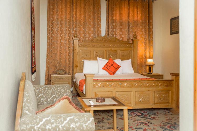 um quarto com uma cama, uma cadeira e um sofá em GOHO Garden View em Gilgit
