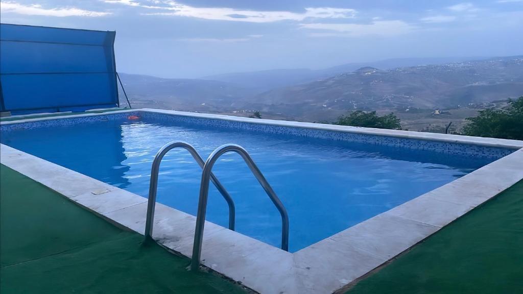 a swimming pool with a view of a mountain at Villa for rent,pool,big terraces,mountain view in Jerash