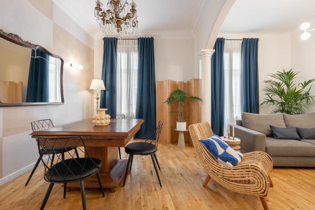uma sala de estar com uma mesa e cadeiras e um sofá em Balmes Apartment by Olala Homes em Barcelona