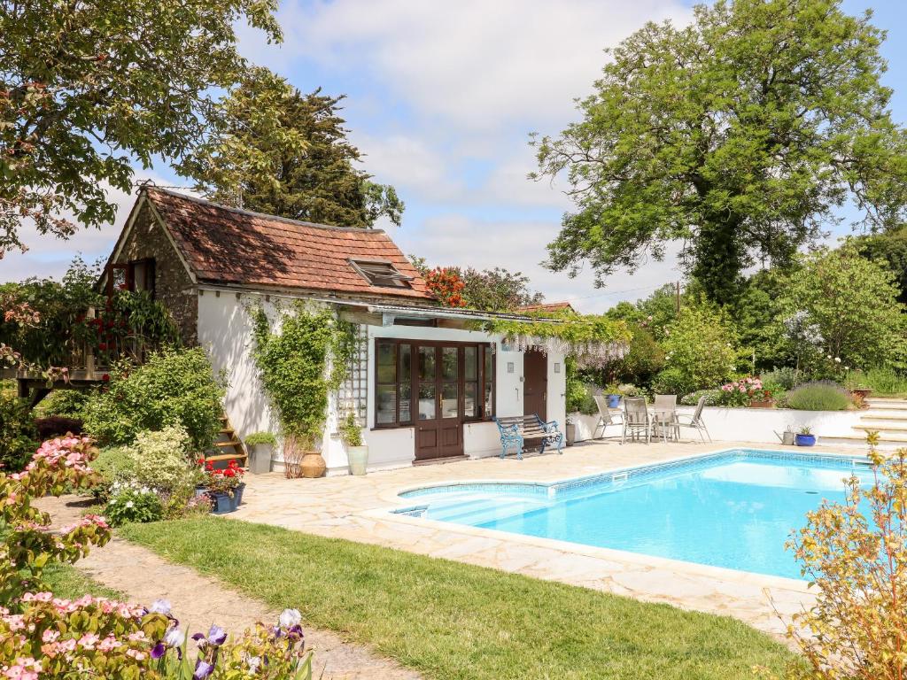 a house with a swimming pool in a yard at Shillings Cottage in Cullompton