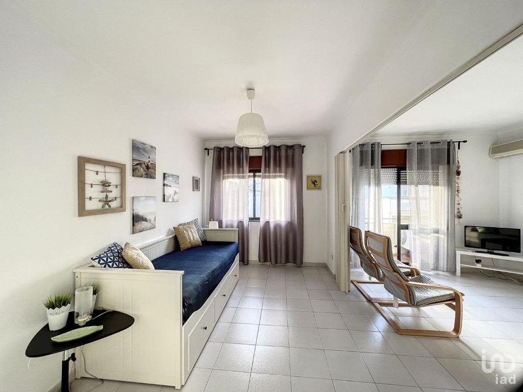 um quarto com uma cama azul e uma sala de estar em T2 ideal para descansar e com Espanha ao lado em Vila Real de Santo António