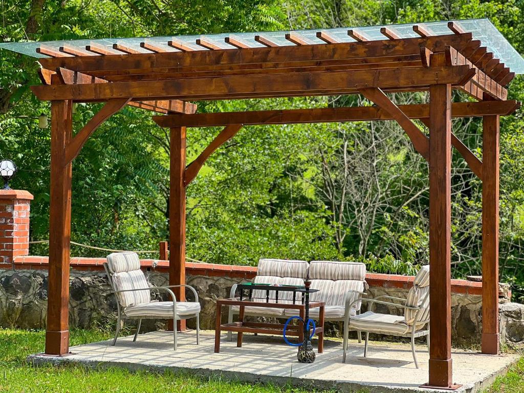 a wooden pergola with three chairs and a table at Heaven Forest Villa in Macka