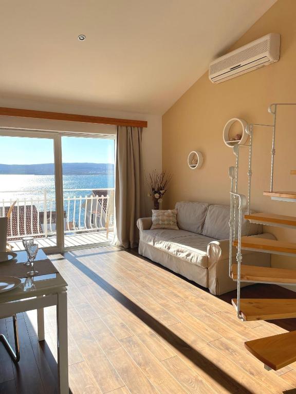 a living room with a couch and a balcony at Apartment Araucaria Gallery in Crikvenica