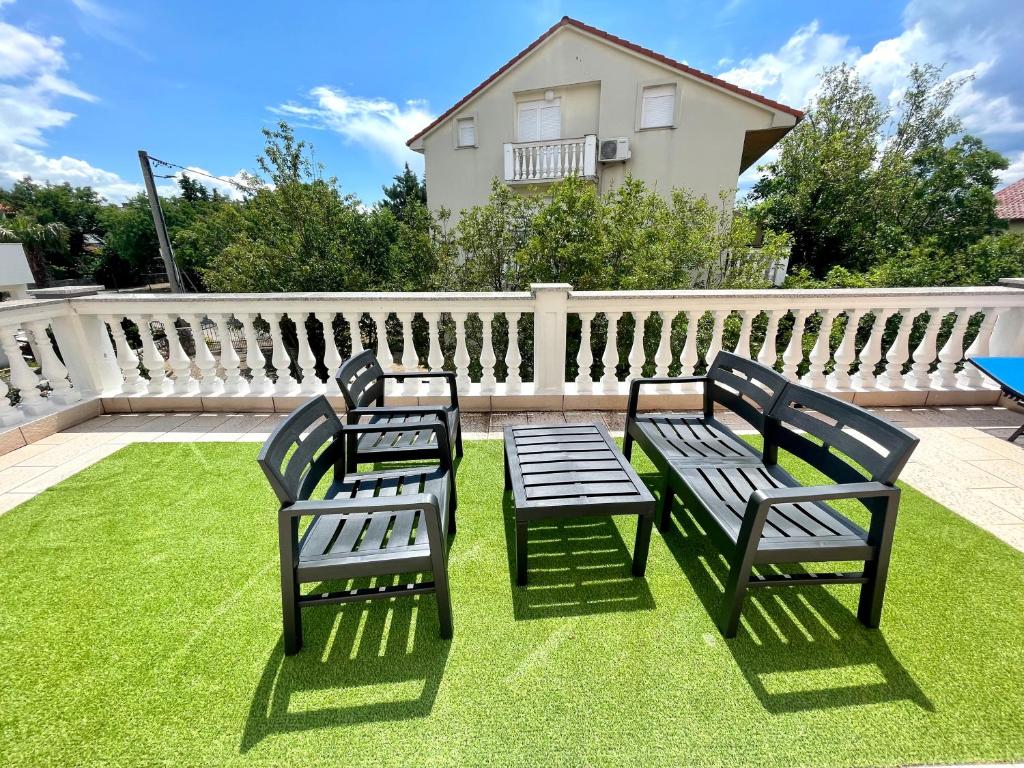 two benches sitting on a lawn in front of a fence at Villa Julie in Jadranovo