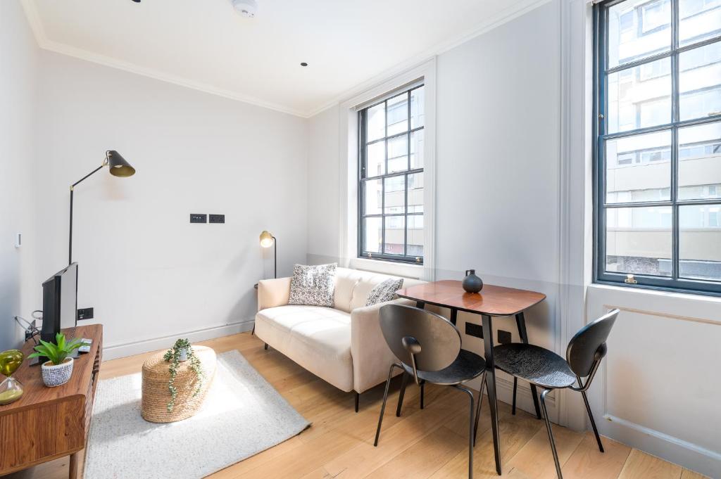 ein Wohnzimmer mit einem Sofa und einem Tisch in der Unterkunft Trendy London Home GS1 in London