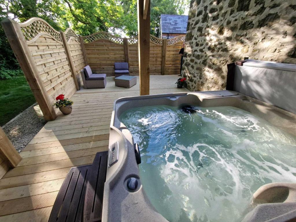 a jacuzzi tub on a deck with a patio at Blackberry Barn in Ballymena