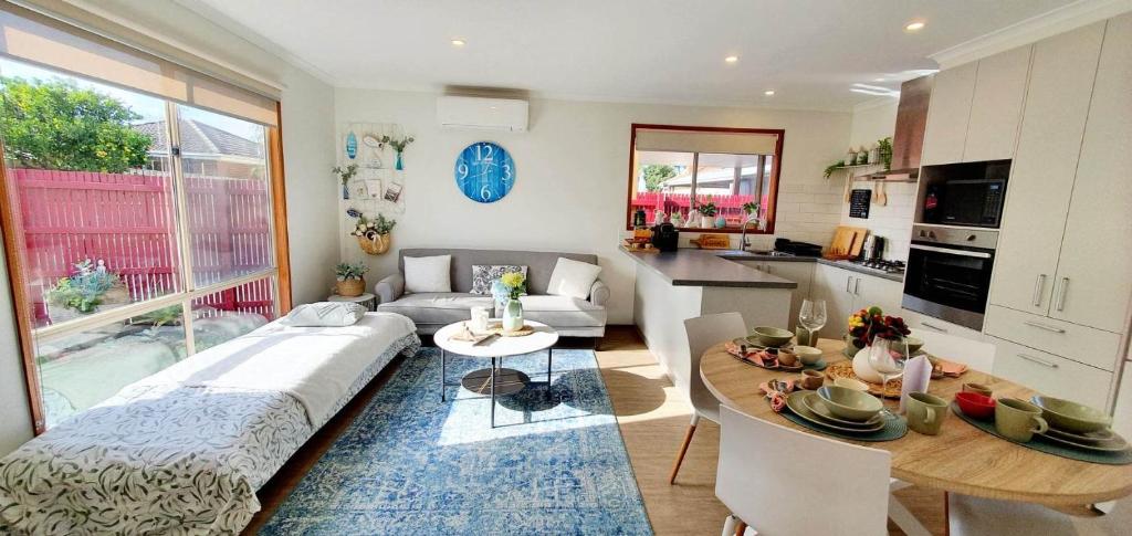 a living room with a couch and a table at Beach Garden Getaway in Cheltenham