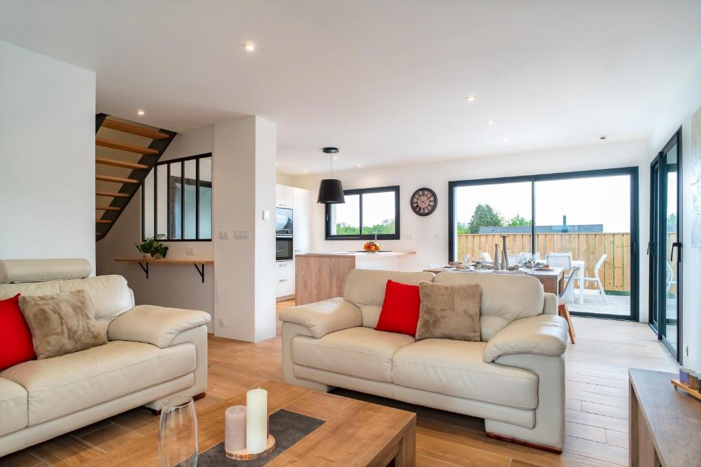 a living room with two white couches and a table at Ti Menhir - Charmante maison pour 6 avec jardin in Plomelin