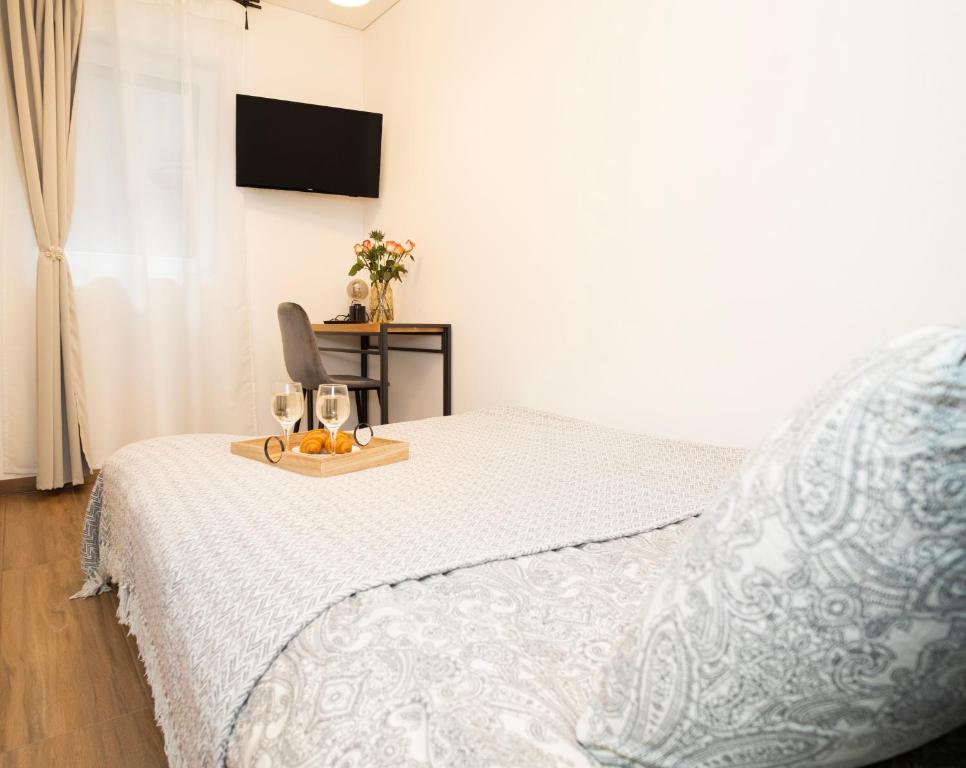 a bedroom with a bed and a desk with a television at Downhill Apartment on the Groundfloor in Kaunas