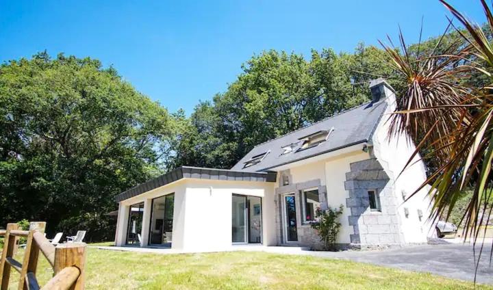 Biały dom z płotem przed nim w obiekcie Le Fusain - Maison climatisée pour 6 w mieście Pont-Aven