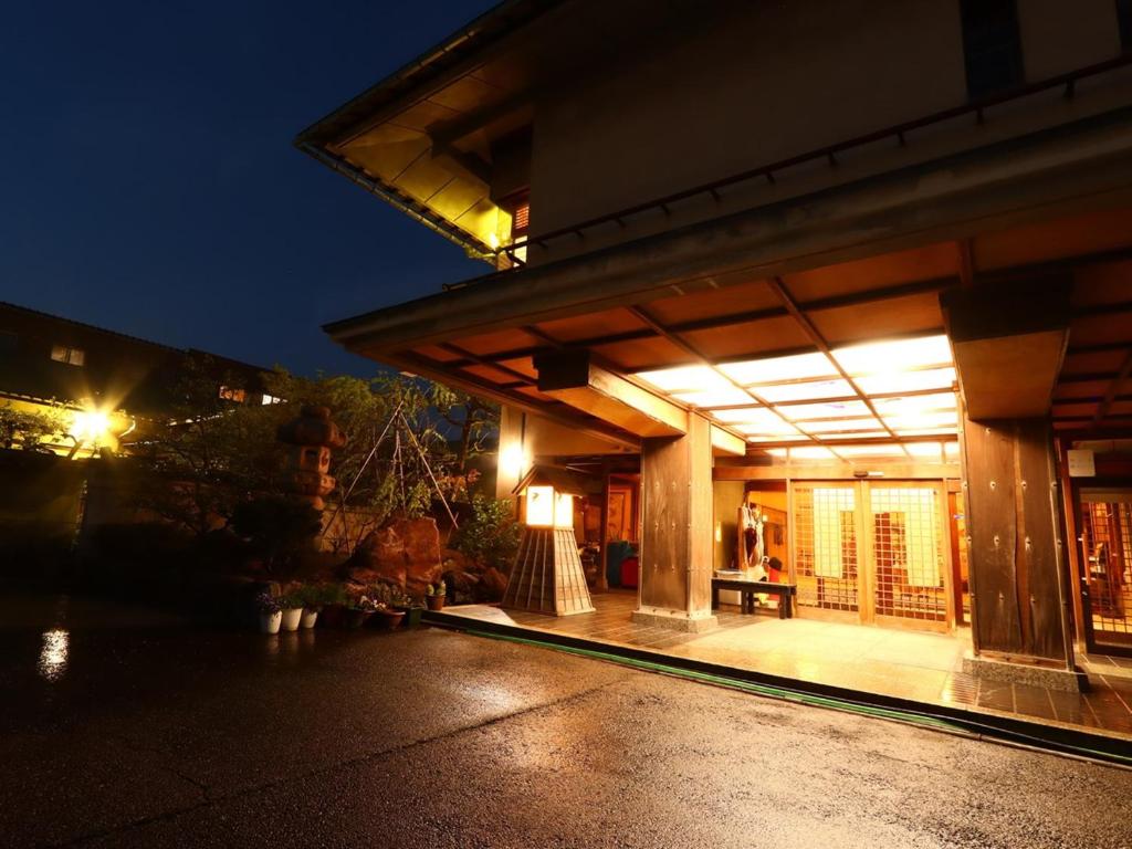 una casa con un porche iluminado por la noche en Ryokan Karasawa en Kanazawa