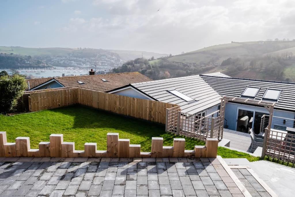 a backyard with a fence and a house at Holiday Home Churchfields - Stunning Views in Dartmouth