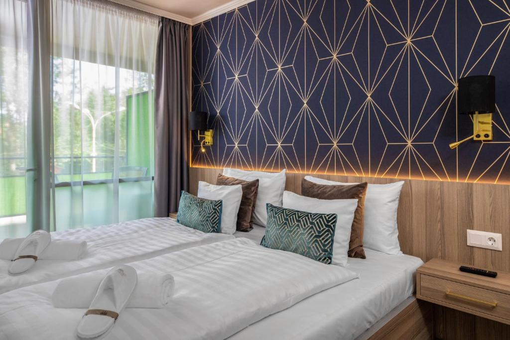 1 dormitorio con 2 camas y pared azul en Vénusz Hotel en Siófok