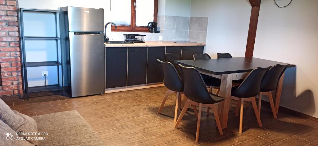 a kitchen with a table and a stainless steel refrigerator at Idea Domki in Mikołajki