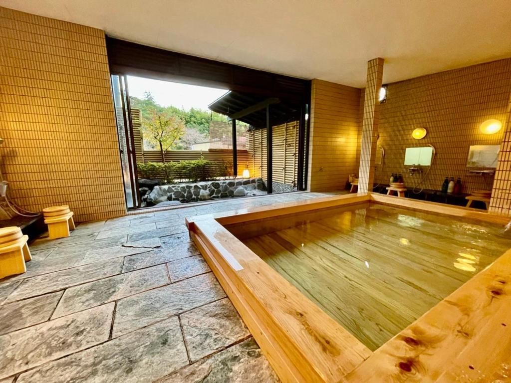 una piscina en una habitación con una ventana grande en Katsura no Izumi, en Izunokuni