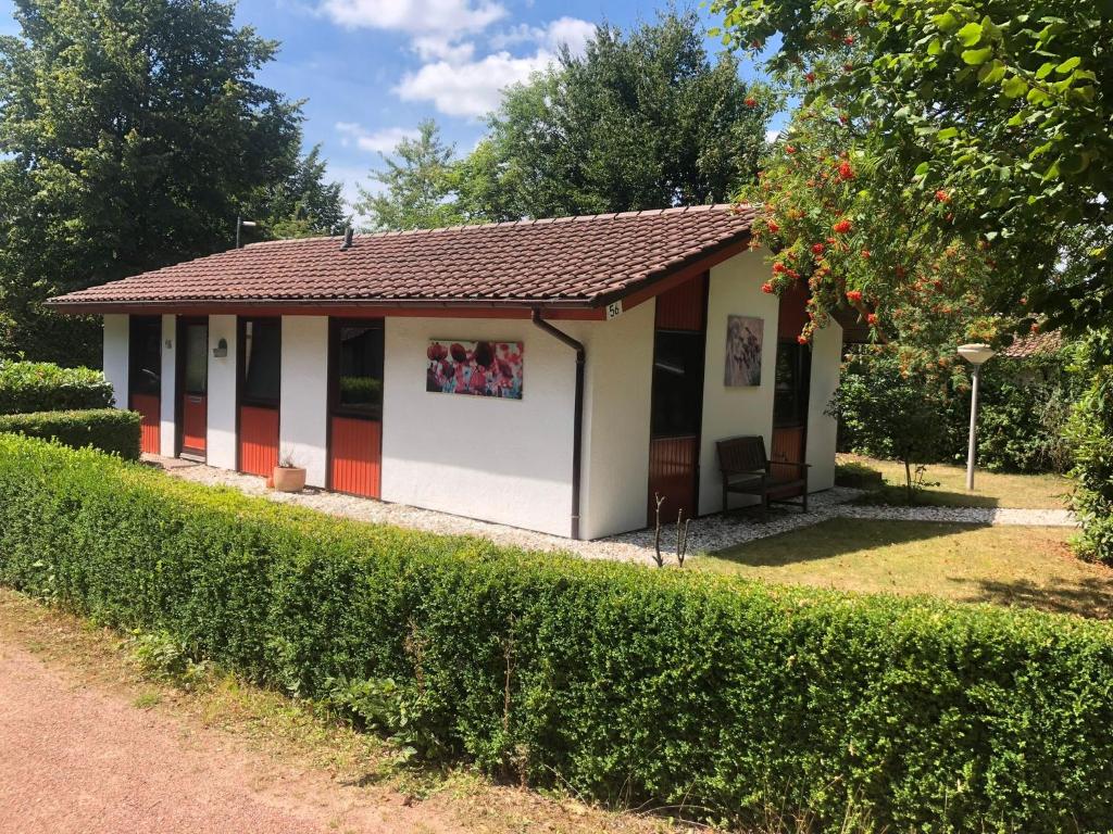 una pequeña casa con techo rojo en Heppenhaus en Uelsen
