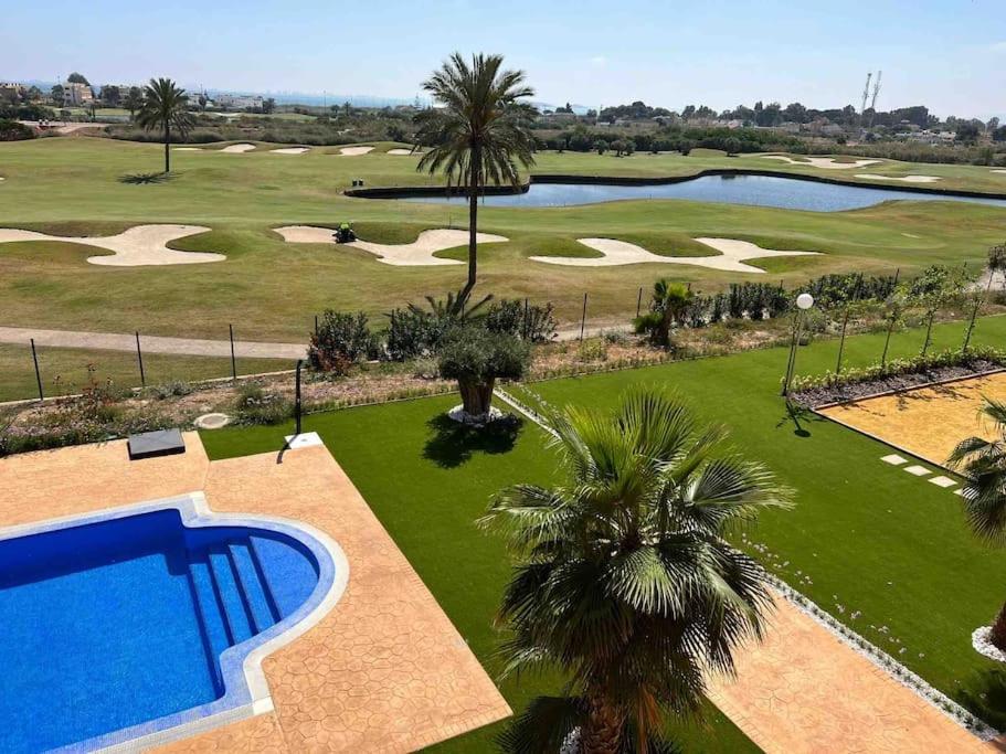 einen Blick über einen Golfplatz mit Pool in der Unterkunft Lujoso ático sobre el golf en los Alcázares in Los Alcázares