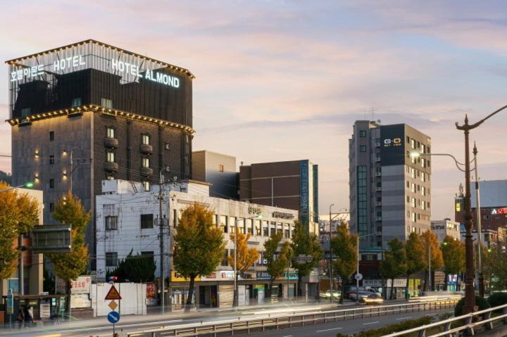 uma cidade com edifícios altos em uma rua da cidade em Almond Hotel Gupo Station em Busan