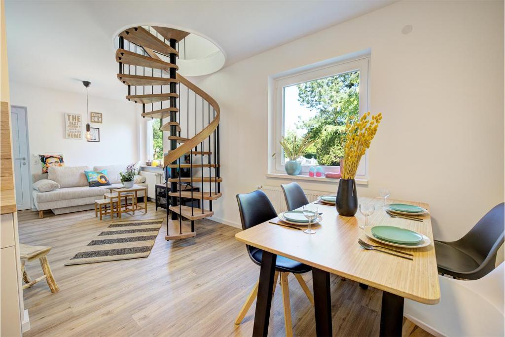 a dining room and living room with a spiral stair at Rehdamm in Heide