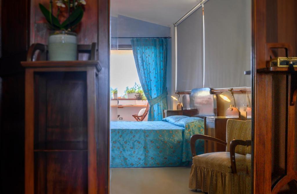 a bedroom with a bed and a window and a chair at Hotel Ristorante Cavaliere in Scario