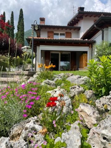 a house with a garden of flowers and rocks at La casa in collina in Caprino Veronese