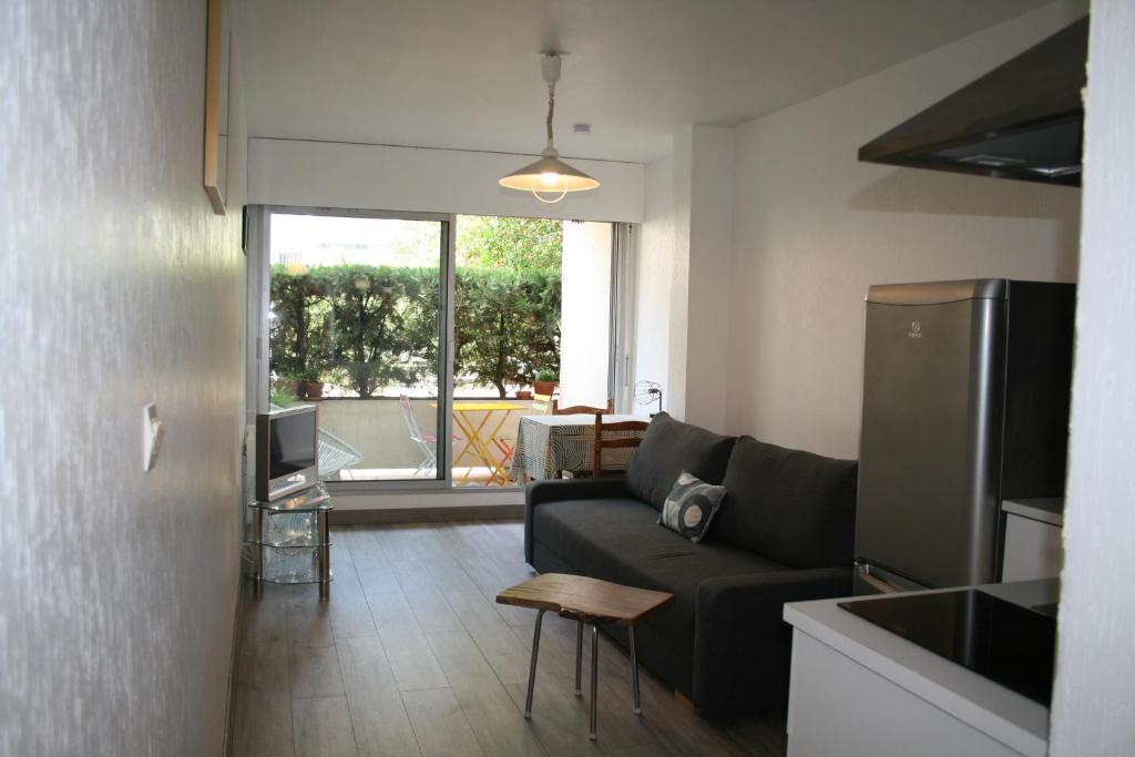 ein Wohnzimmer mit einem Sofa und einem Tisch in der Unterkunft Studio centre-ville, Terrasse, Parking in Montpellier