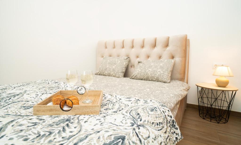a bed with a wooden tray with a clock on it at Downhill Apartment with a Private Terrace in Kaunas