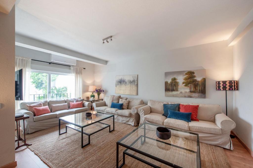 ein Wohnzimmer mit einem Sofa und einem Tisch in der Unterkunft O&L Aire - Spacious and Bright Apartment in the Heart of Seville in Sevilla